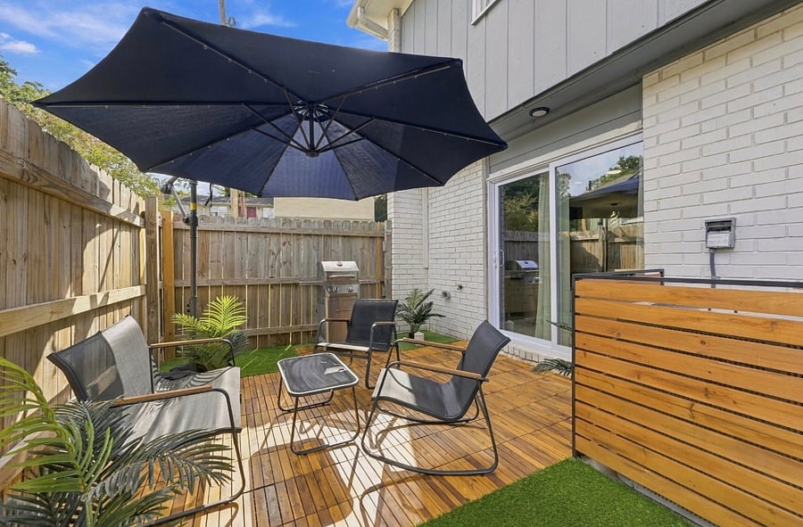 Private furnished outdoor patio with umbrella and seating