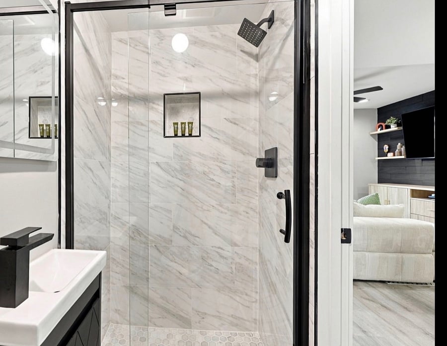 Walk-in glass shower with marble-look tile