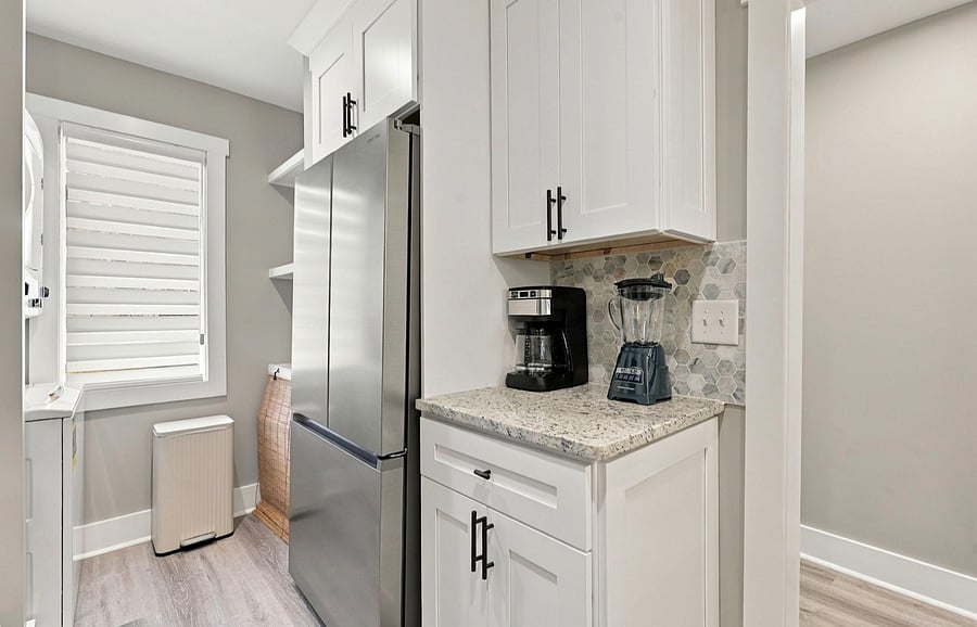Kitchen with full-size stainless fridge and coffee station