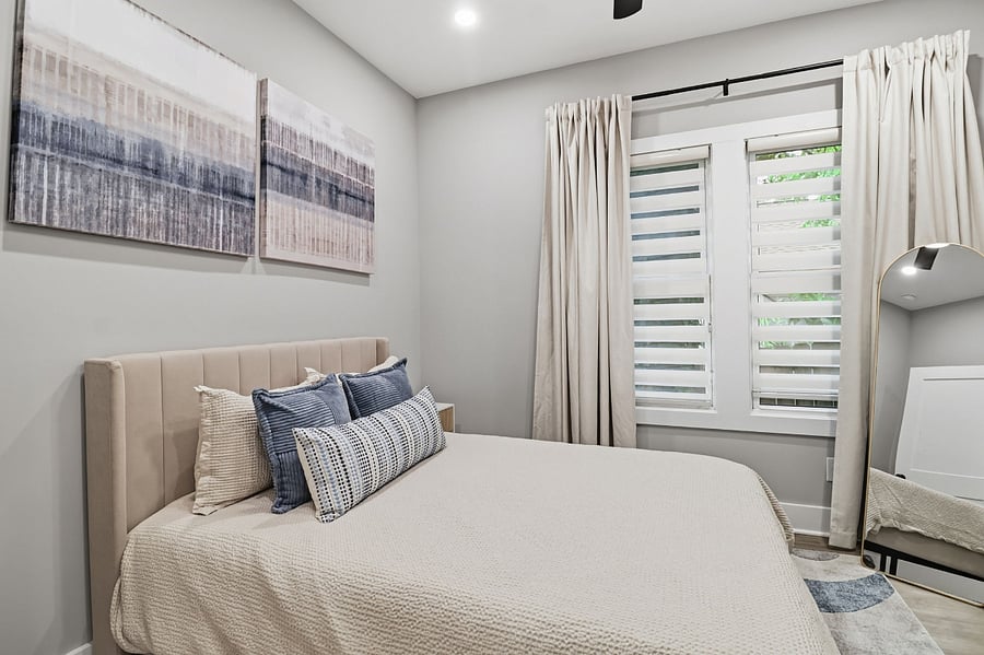 Second bedroom with queen bed and window shades